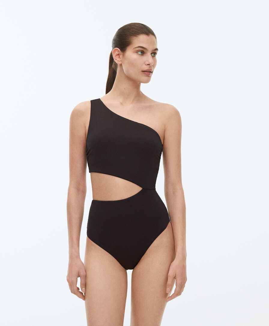 Black Non-wired swimsuit with asymmetric neckline and removable cups. Cut out detail on the back and waist. Fabric with recycled polyamide.
