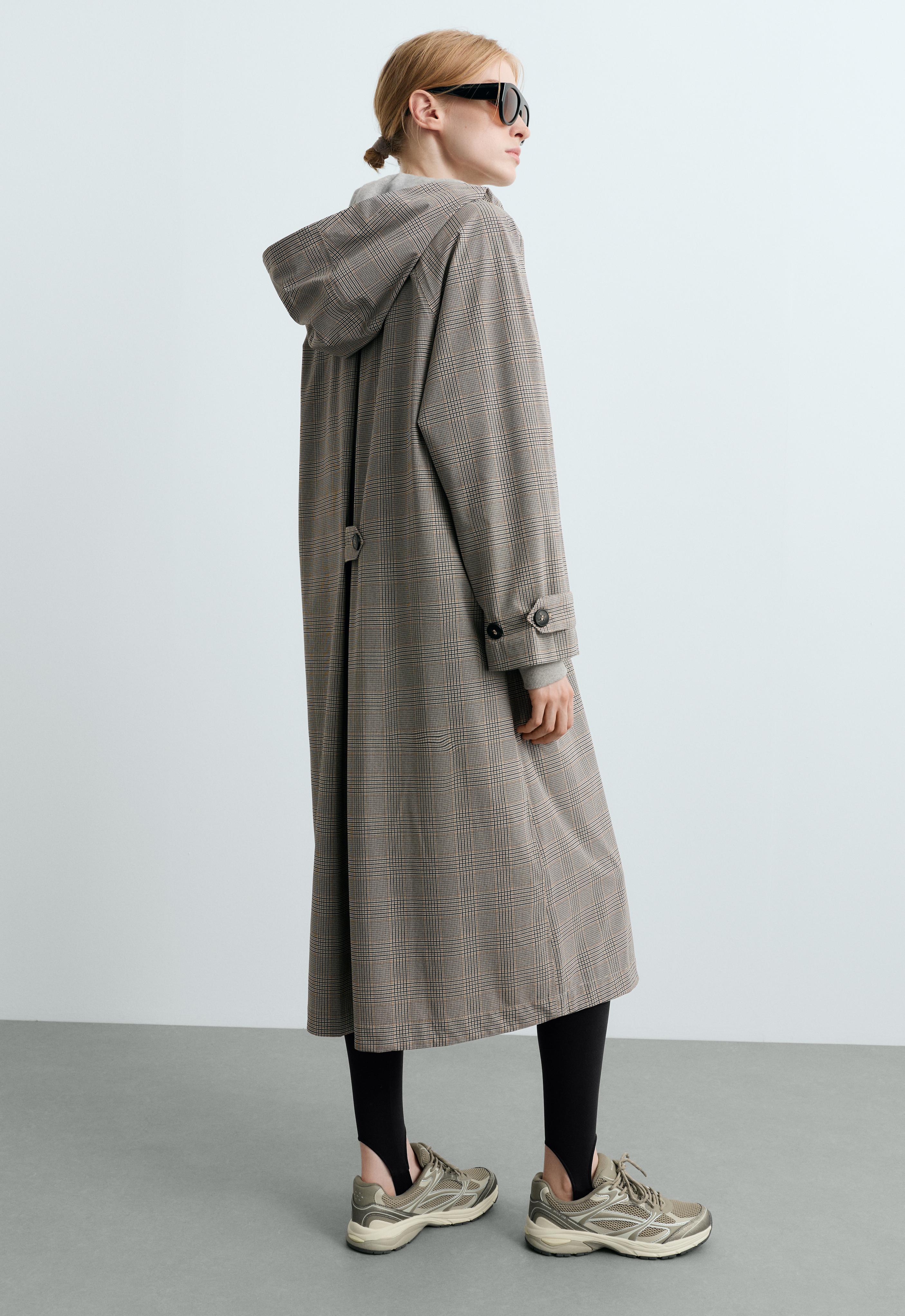 Long plaid hooded jacket set with tab cuffs, black stirrup leggings, and sneakers.