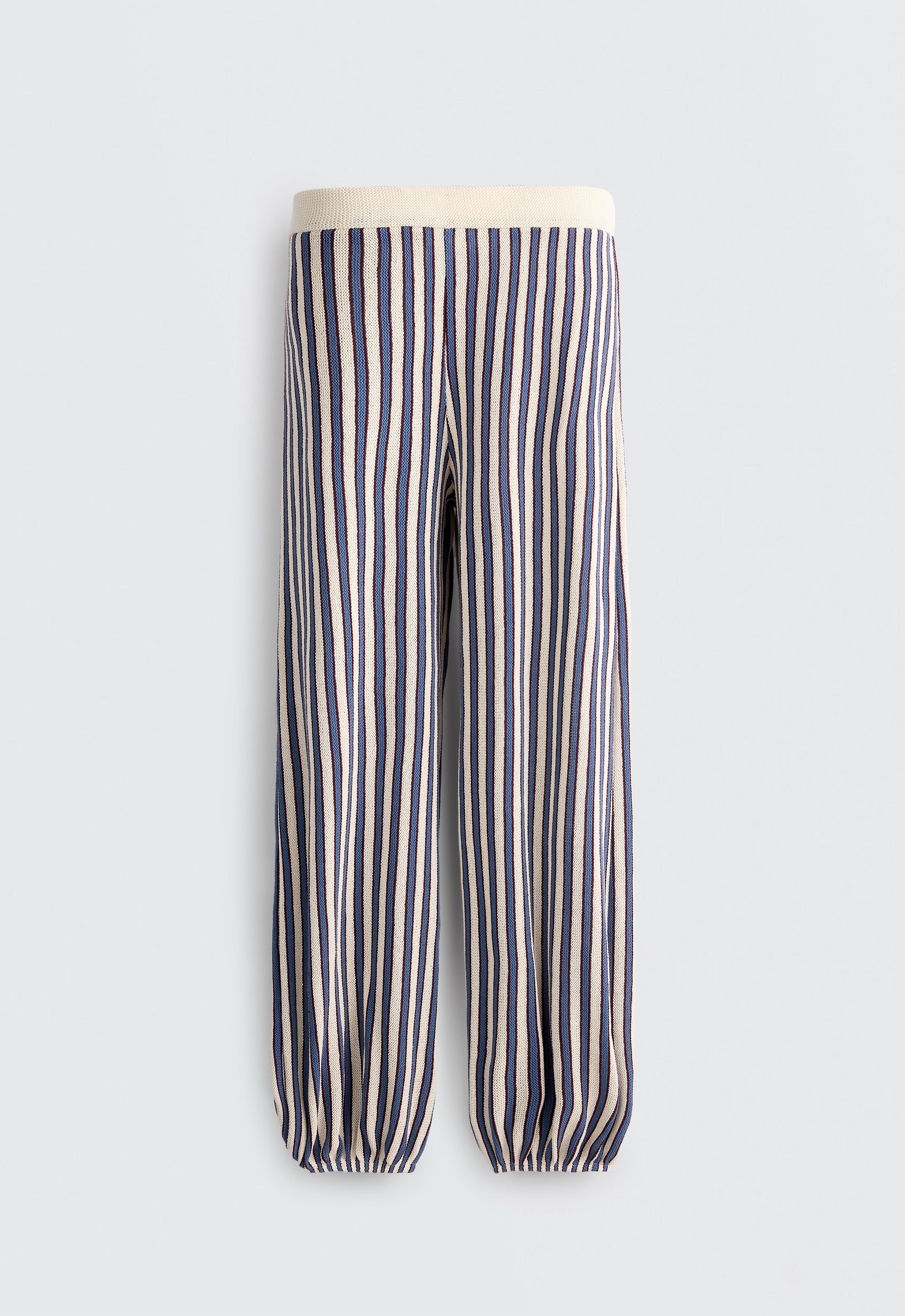 Front view of long, loose-fitting pants with vertical lavender-blue and white stripes, featuring an elastic waistband and cuffs.