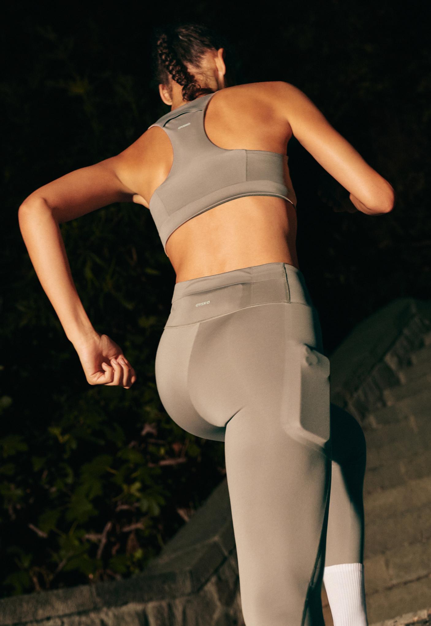 Tank top and high-waisted leggings set in dark taupe with a side pocket. OYSHO text on the back of the garments.