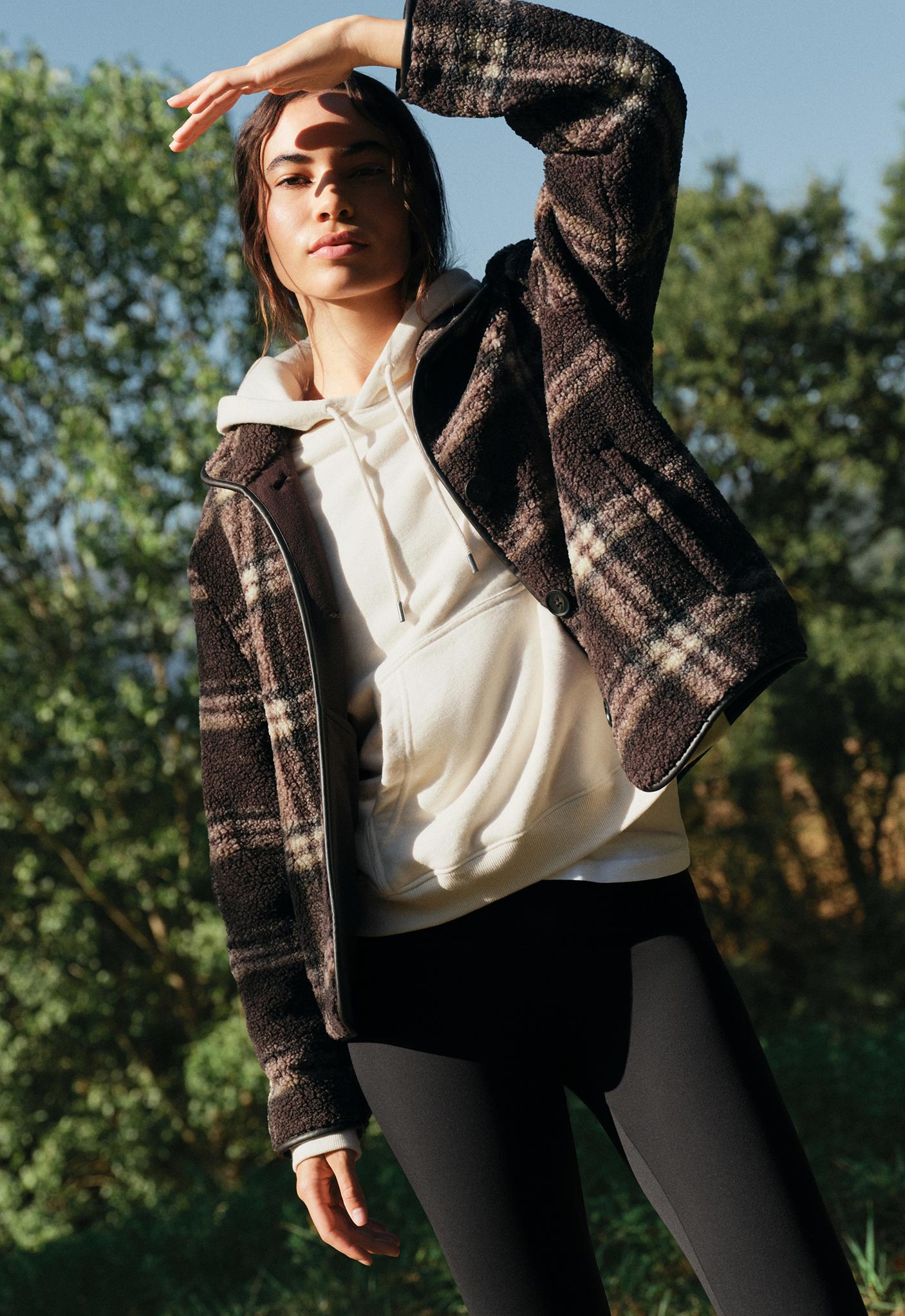 Plaid jacket set, light ecru hooded sweatshirt with drawstrings and a front pocket, and black pants.