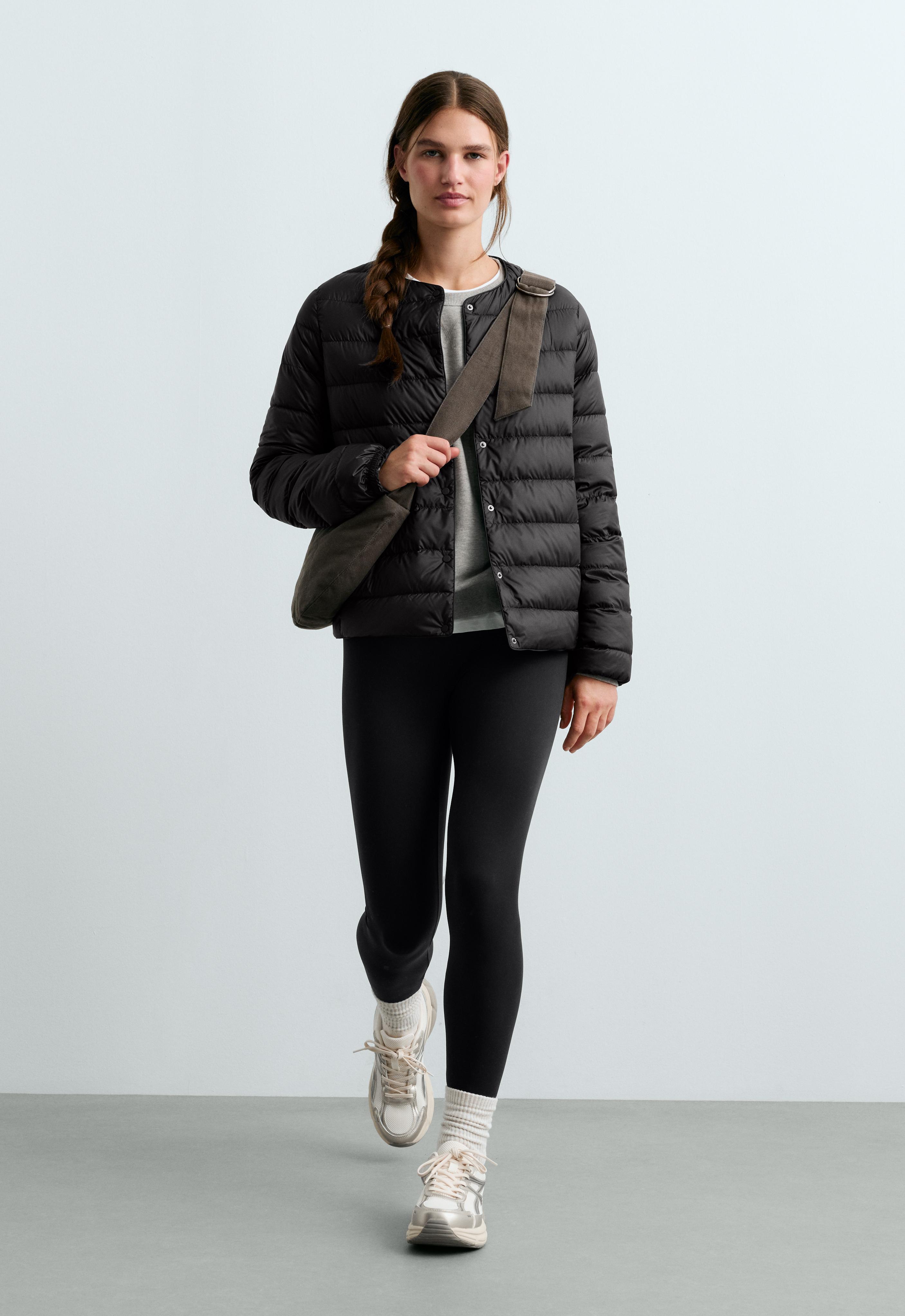 Set consisting of a black quilted jacket with a round neckline and snap buttons, a gray T-shirt, black leggings, and sneakers.