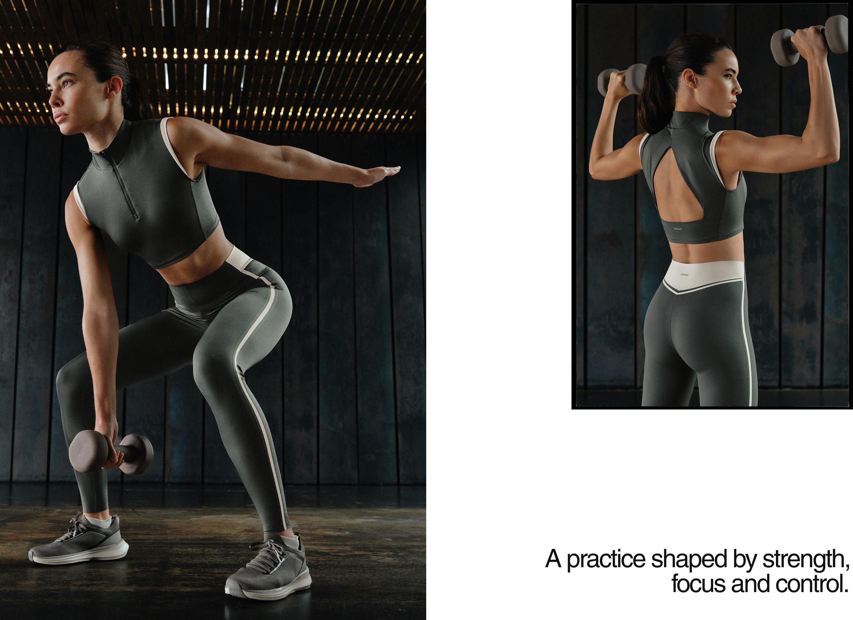 Dark gray cropped top set with a high zip-up neckline and open back, and leggings with white side stripes.