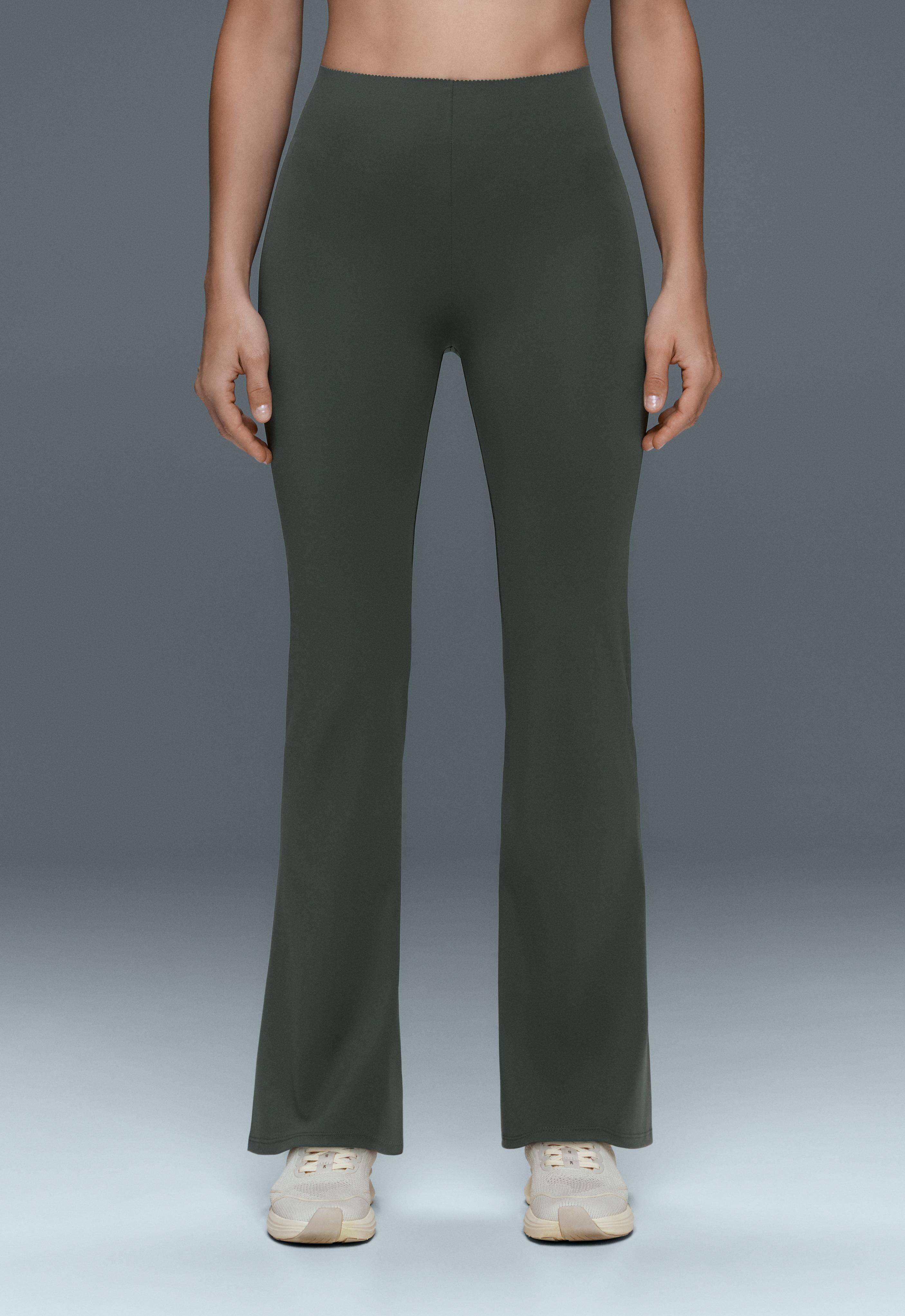 Medium shot of dark green high-waisted, fitted pants with flared hems.
