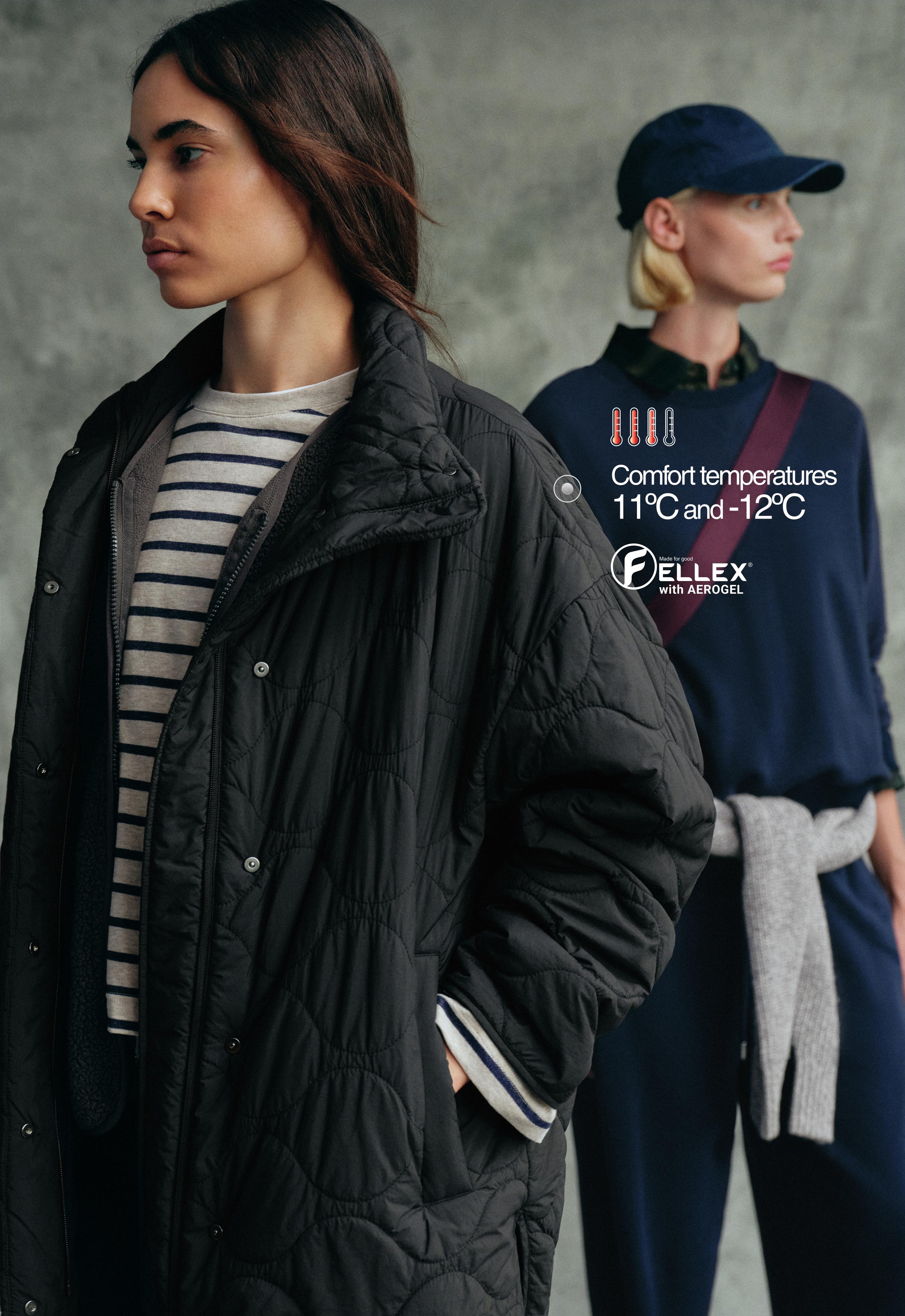 Medium shot of a black jacket with wavy quilting, a high collar, and snap buttons, over a striped T-shirt.