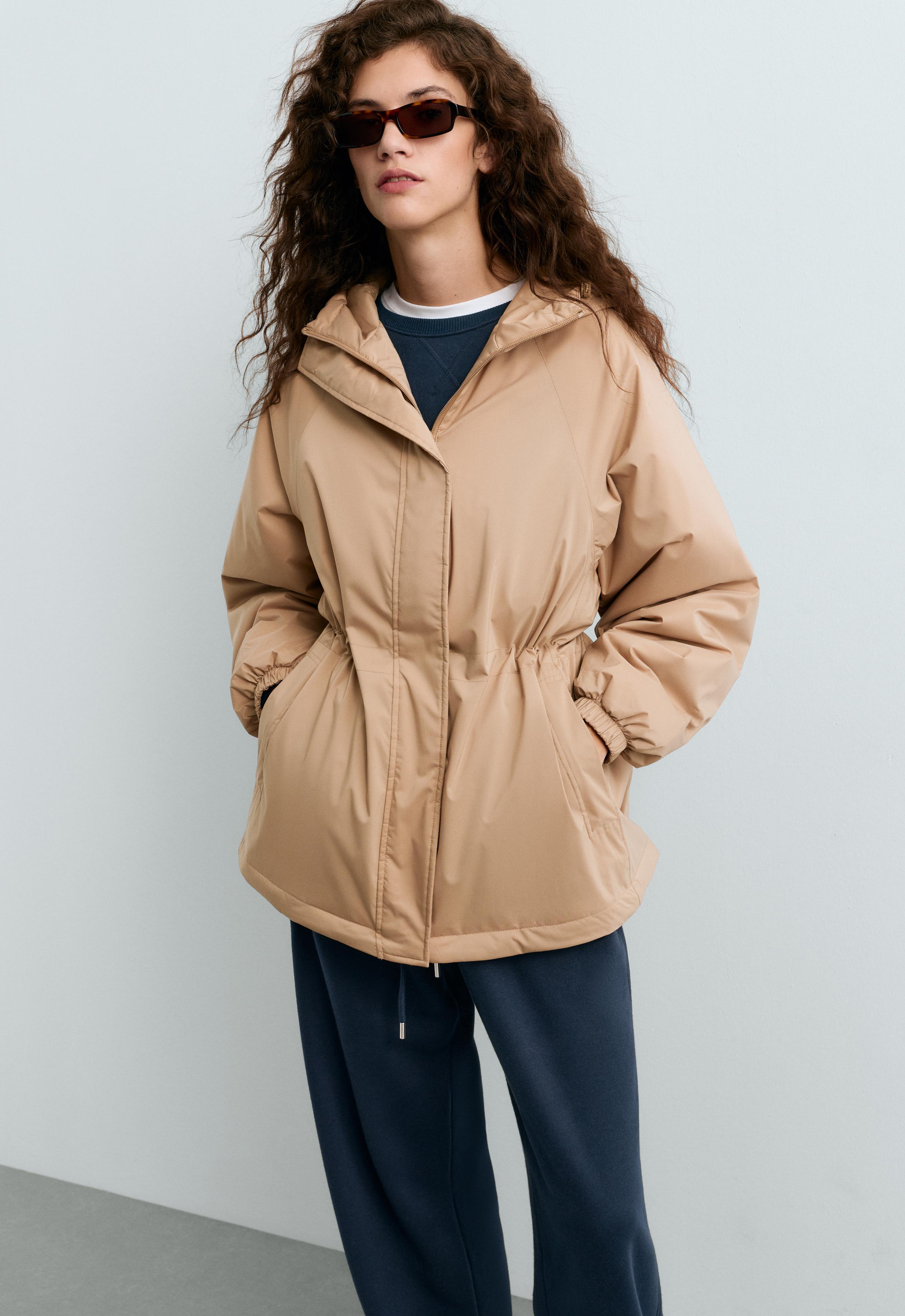 Dark camel hooded jacket set with a fitted waist, elastic cuffs and side pockets, dark blue top and pants.