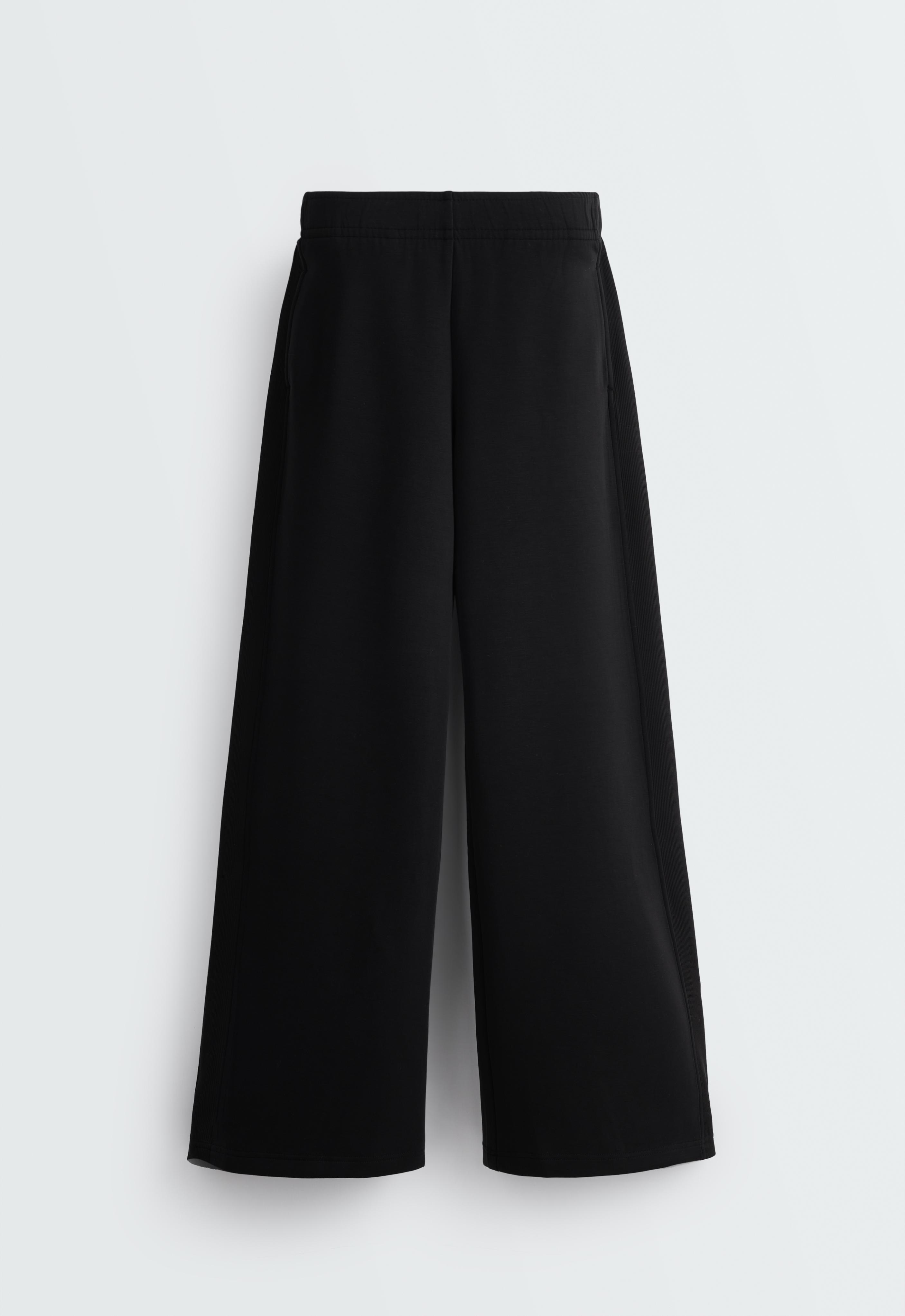 Front view of wide-leg straight-cut black long pants with an elastic waistband and front pockets.